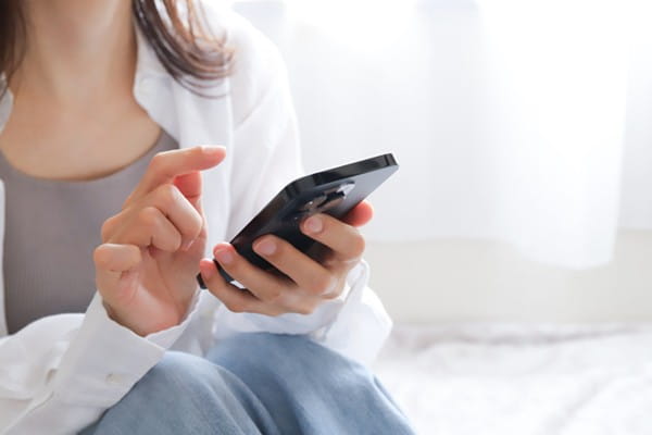 スマホで電話占いをする女性